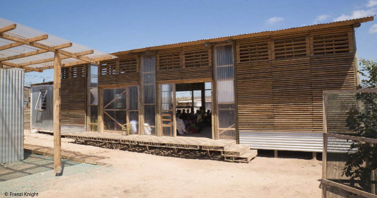 A community meeting in a building made of recycled materials.